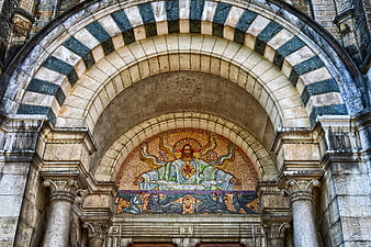 Historic Cathedral Facade With Striped Arch And Religious Mosaic
