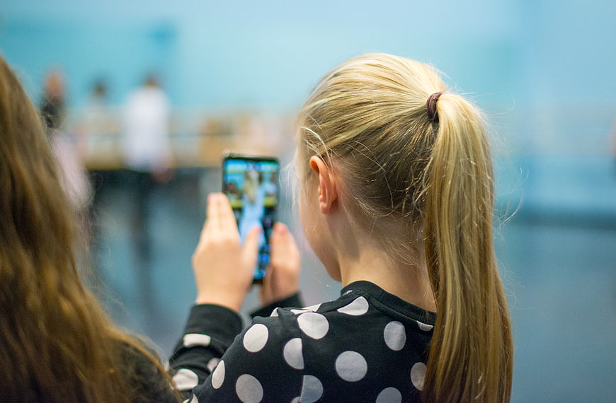 Girl taking photo with smartphone at event