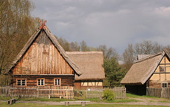 Traditional wooden cottages with thatched roofs in open-air museum