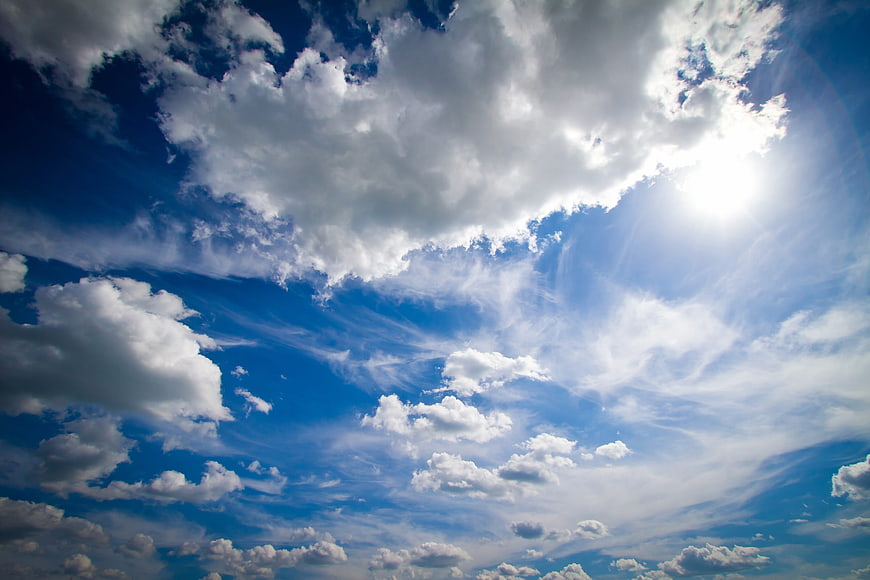 Dramatic Blue Sky with Fluffy White Clouds and Sunlight