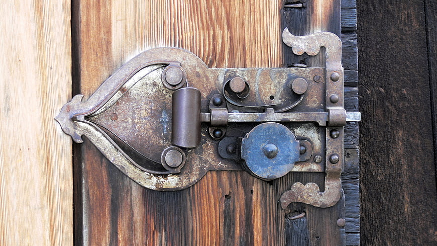 Antique Rusty Iron Lock on Weathered Wooden Door