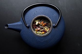 Top view of blue cast iron teapot with herbal tea ingredients