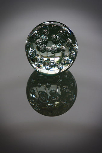 Glass Paperweight with Bubbles on Gray Background