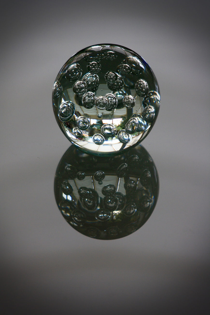 Glass Paperweight with Bubbles on Gray Background