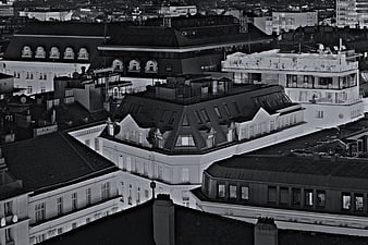 Black and white aerial view of European city rooftops at night