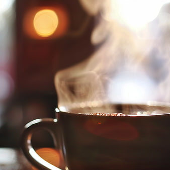 Close-up of Steaming Hot Coffee Cup with Bokeh Background