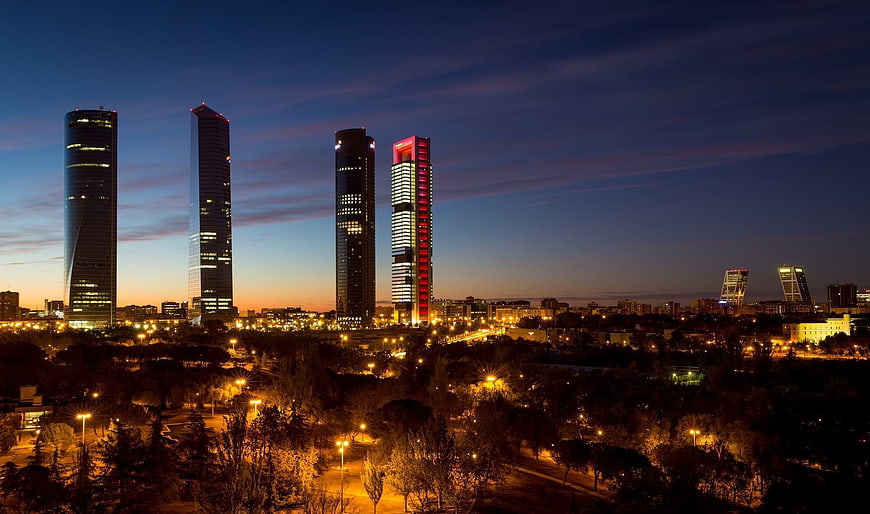 Madrid skyline at dusk with illuminated skyscrapers and park