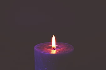 Purple Candle Burning in Dark Room with Flame