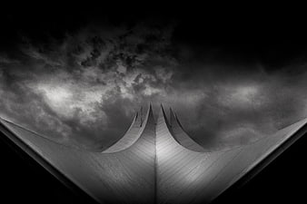 Dramatic black and white architectural roof against stormy sky