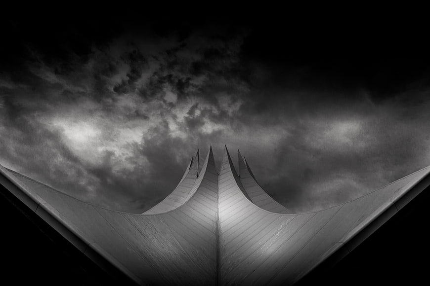 Dramatic black and white architectural roof against stormy sky