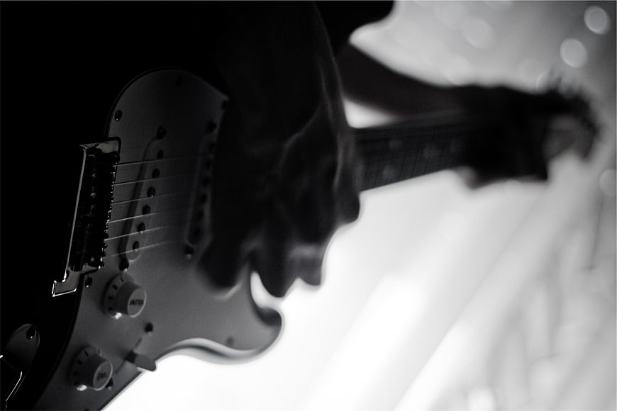 Black and white close-up of electric guitar being played