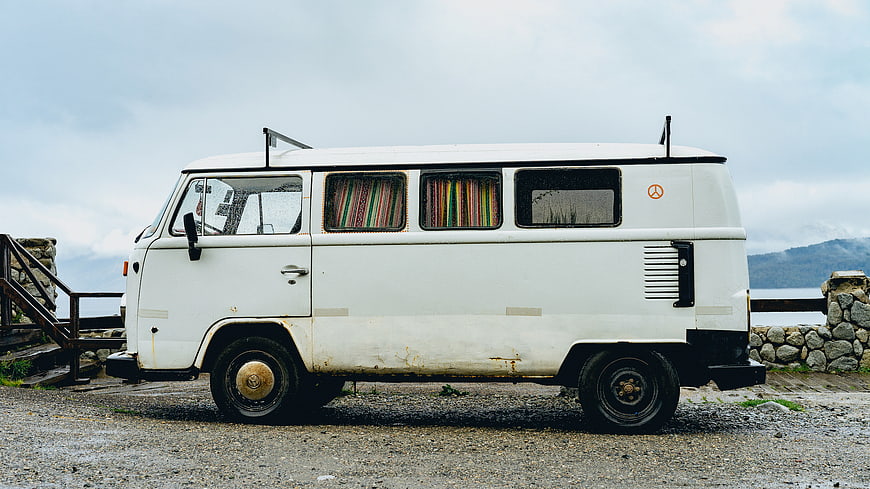 Vintage White VW Bus Parked by the Sea