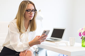 Concerned Businesswoman Checking Smartphone at Office Desk