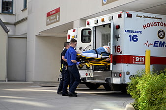 Paramedics Transporting Patient On Stretcher Into Houston Ambulance