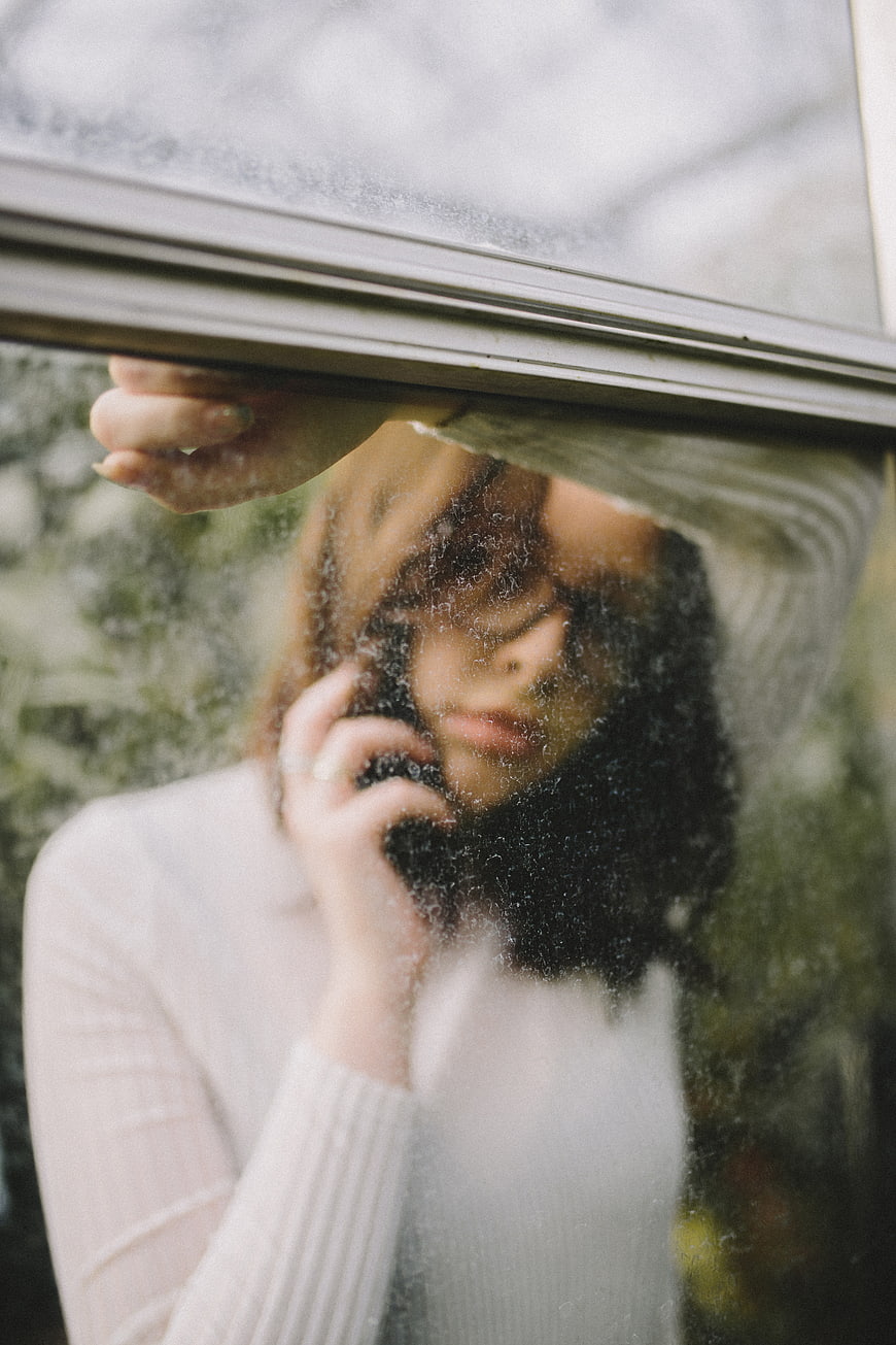 Woman talking on phone through frosted window glass