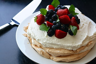 Pavlova Cake Topped With Fresh Mixed Berries And Whipped Cream
