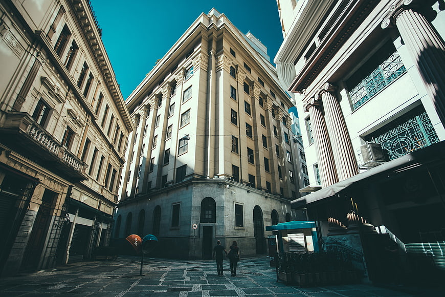Low angle view of historic city buildings with couple walking