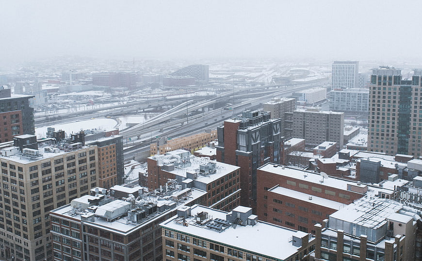 Aerial View of Snowy Cityscape with Highways and Buildings