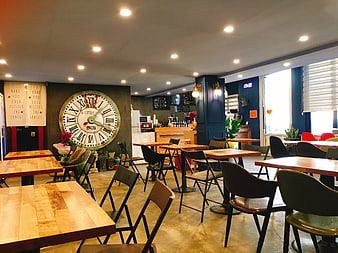 Modern Cafe Interior With Large Wall Clock And Wooden Tables