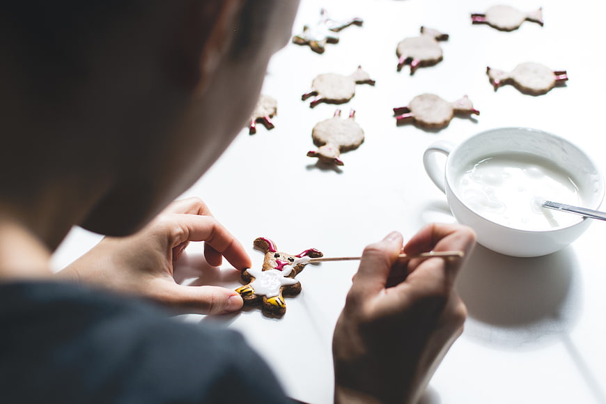 Over-the-shoulder view of hands decorating Easter bunny cookies