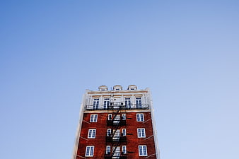 Low angle view of red brick building against blue sky