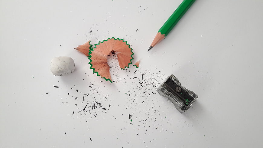 Green Pencil, Sharpener, and Eraser on White Surface
