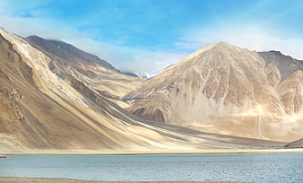 Scenic view of arid mountains and blue lake in Ladakh