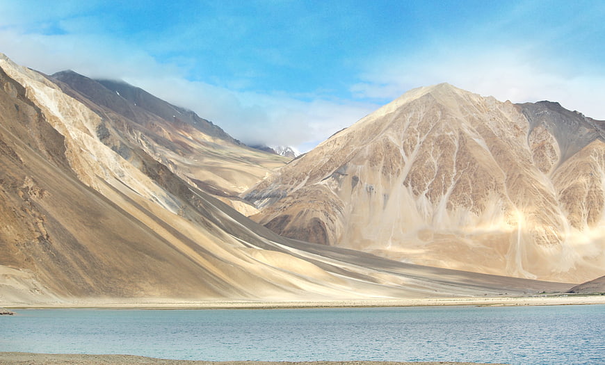 Scenic view of arid mountains and blue lake in Ladakh