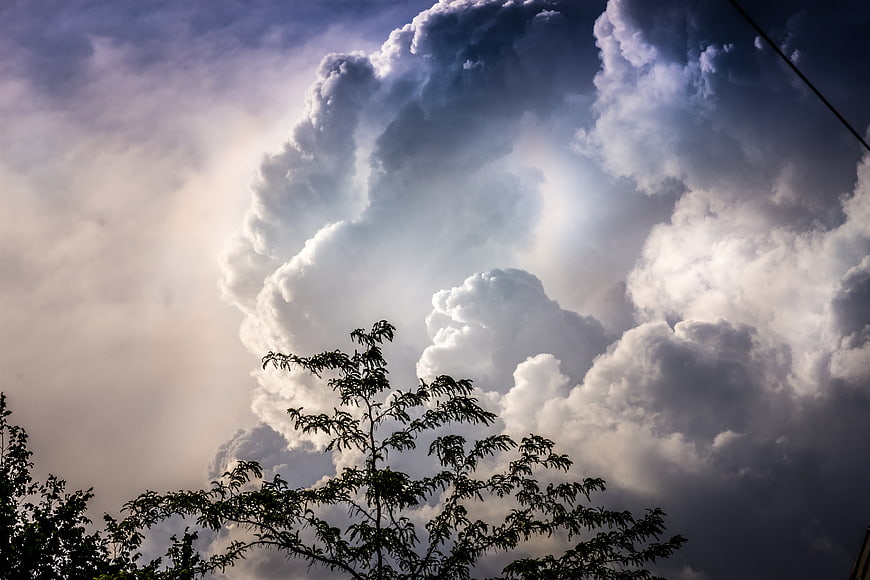 Dramatic Storm Clouds with Sun Rays and Silhouetted Trees