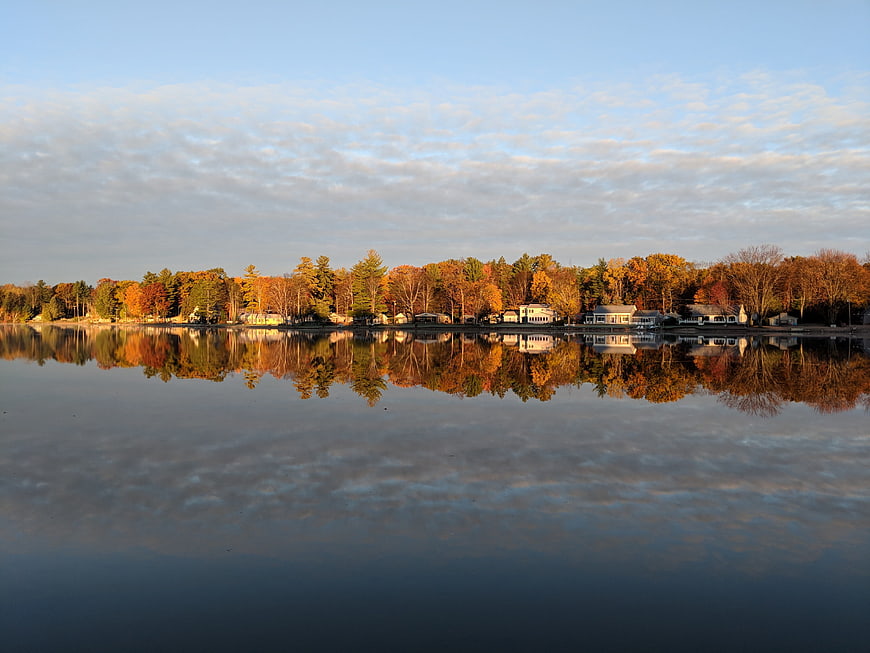 Serene Autumn Lake Reflection with Colorful Trees and Houses