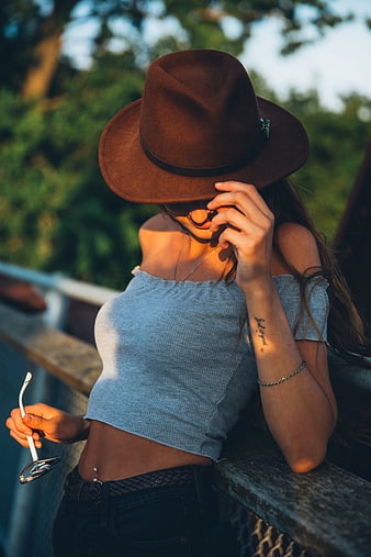 Woman in Fedora Hat and Off-Shoulder Top Leaning on Railing