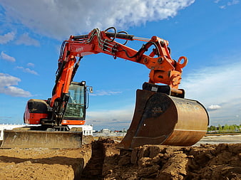 Orange Excavator Digging Trench At Construction Site