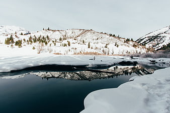 Winter Landscape with Snowy Mountains and River Reflection