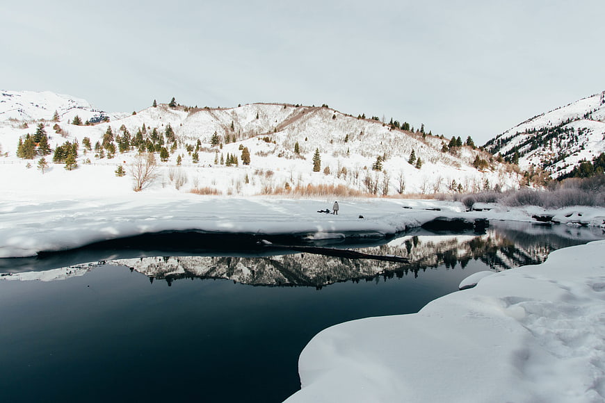 Winter Landscape with Snowy Mountains and River Reflection
