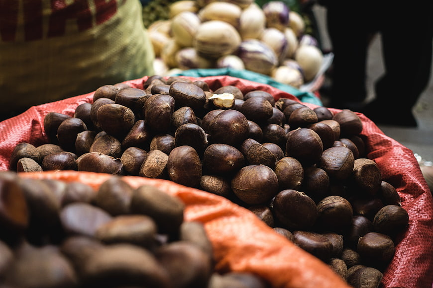 Fresh chestnuts in red sack at farmers market