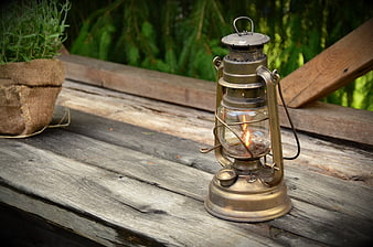 Vintage Kerosene Lantern Burning On Weathered Wooden Table