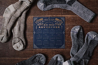 Vintage Adventure Calendar Surrounded by Wool Socks on Wood