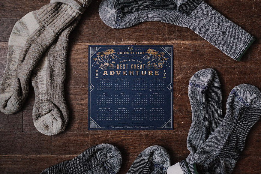 Vintage Adventure Calendar Surrounded by Wool Socks on Wood