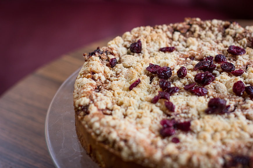 Close-up of cranberry crumble cake on wooden board