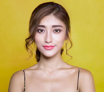 Portrait of beautiful woman with pink lipstick on yellow background