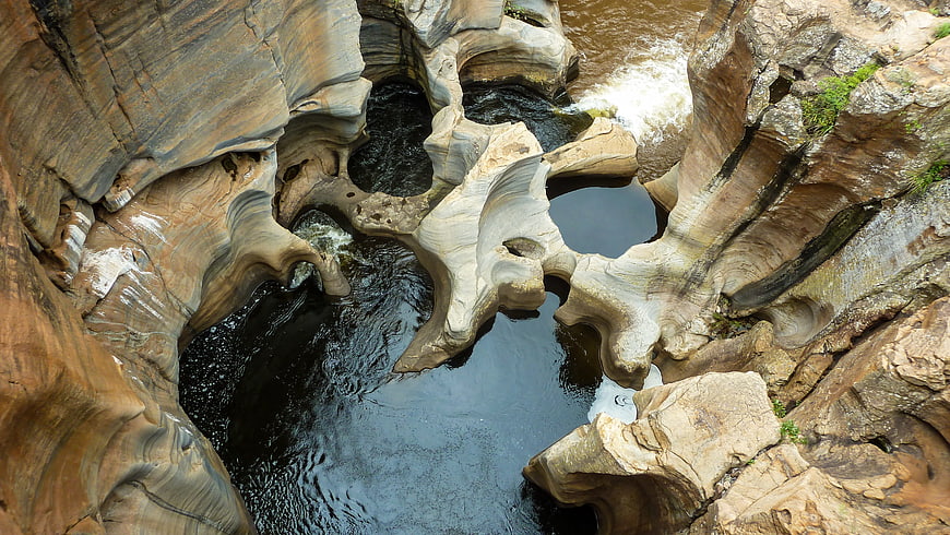 Aerial view of swirling rock formations and river canyon