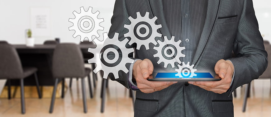 Businessman holding tablet with holographic gears
