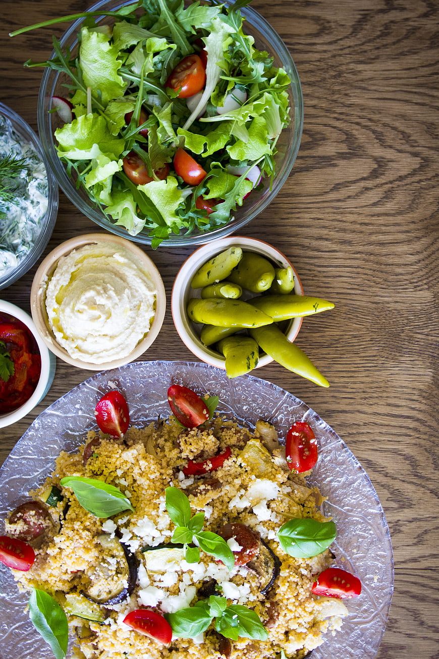 Overhead view of Mediterranean couscous meal with salad and dips