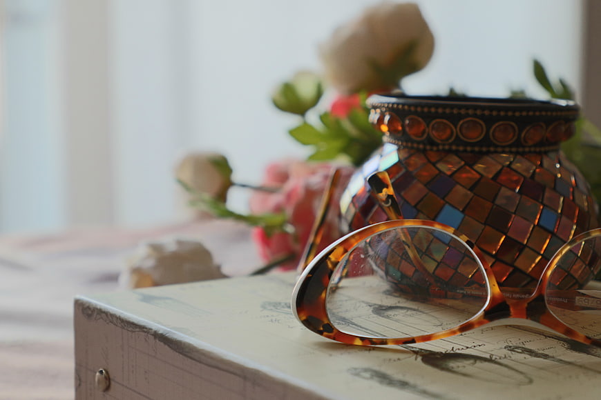Tortoiseshell Glasses on Vintage Book with Mosaic Vase