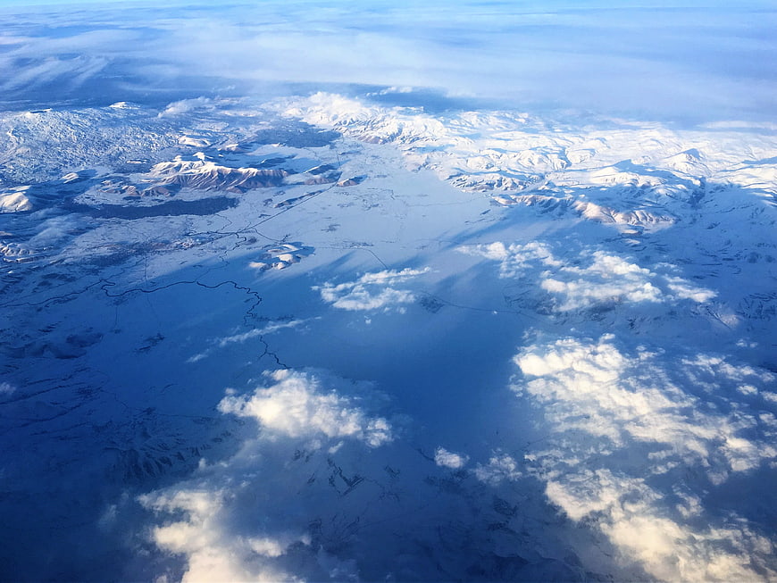 Aerial View of Snow-Covered Mountains and Clouds