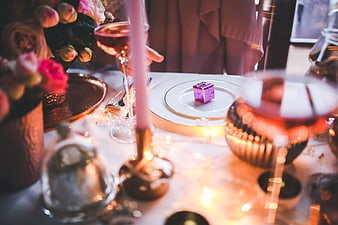 Festive holiday table setting with wine, candles, and gift