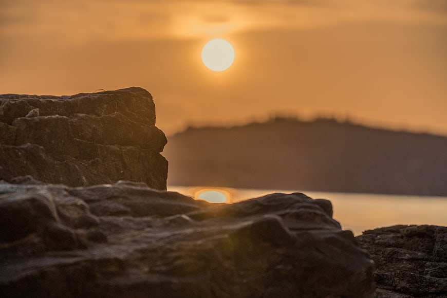 Golden sunset over rocky coastline with blurred background