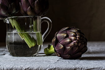Purple Artichokes in Glass Pitcher and on Table