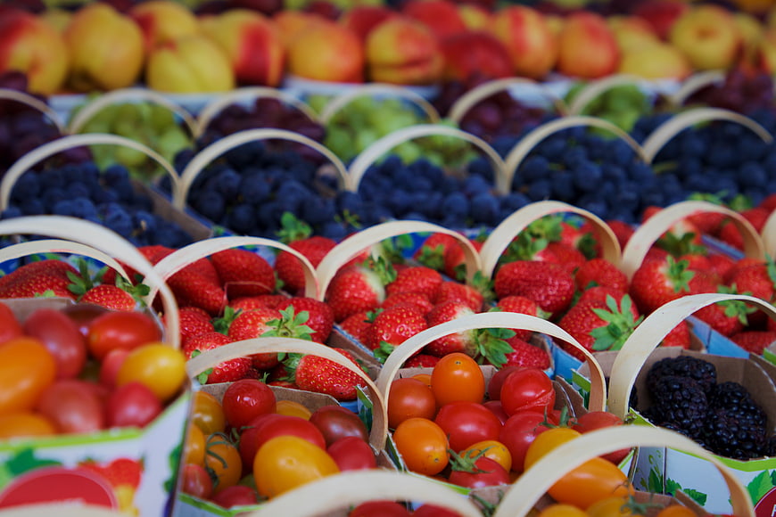 Fresh Assorted Berries and Tomatoes in Market Baskets