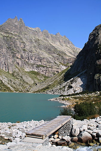 Alpine Lake with Wooden Bridge and Rocky Mountains